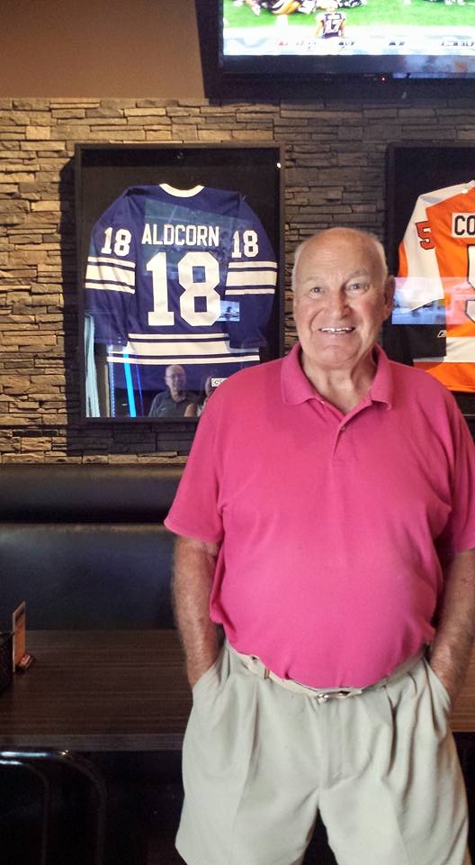 Gary Aldorn standing in front of his jersey at Overtime.